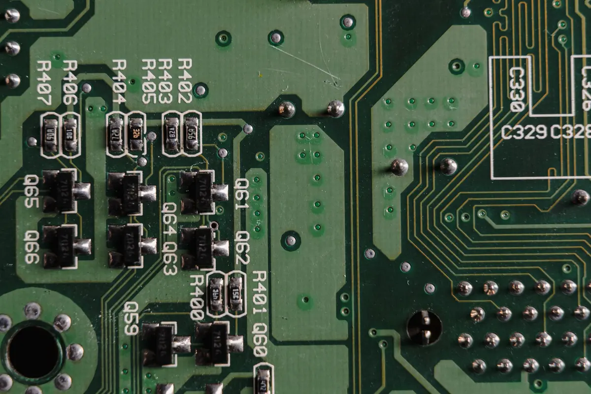 Close-up of a green circuit board with small transistors and resistors.