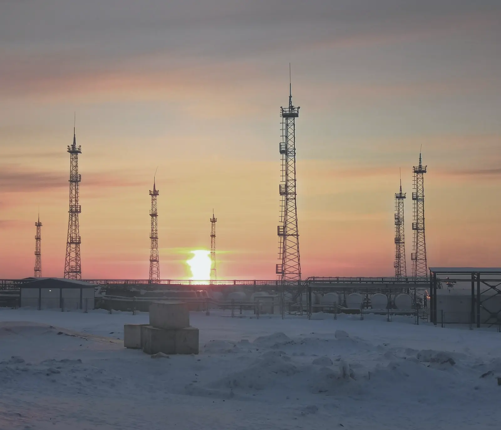 Radio masts on snow-covered open ground at dusk.